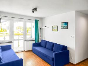 a living room with a blue couch and a window at Luna Port w Rowach in Rowy