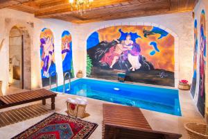 a pool in a room with a painting on the wall at Black Stove Cappadocia in Ortahisar