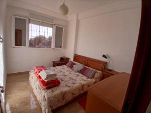 a bedroom with a bed with a red blanket on it at Découvrez ce havre de paix in Imi Ouaddar