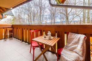 a porch with a table and chairs and a window at VacationClub - Leśny Dom 18A Apartament 25 in Karpacz