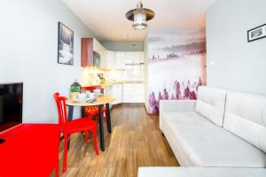 a living room with a couch and a table at VacationClub - Leśny Dom 18A Apartament 25 in Karpacz
