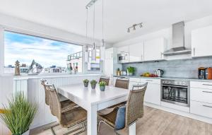 une cuisine blanche avec une table et des chaises blanches dans l'établissement Lovely Ship In Olpenitz With Sauna, à Olpenitz