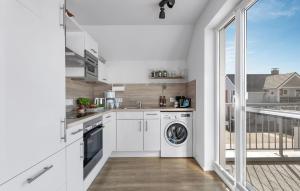a kitchen with a washing machine and a balcony at Strand 11 in Olpenitz +29 photos