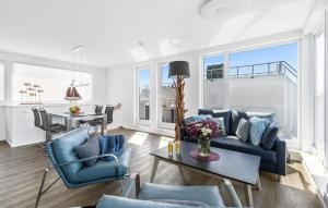 een woonkamer met een blauwe bank en een tafel bij Sunseeker in Olpenitz