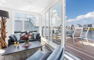 een woonkamer met een bank en een tafel op een balkon bij Sunseeker in Olpenitz