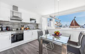 een keuken met een eettafel en een boot in het raam bij Sunseeker in Olpenitz +17 foto's