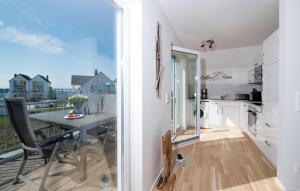 a kitchen and dining room with a table and a balcony at Windrose in Olpenitz