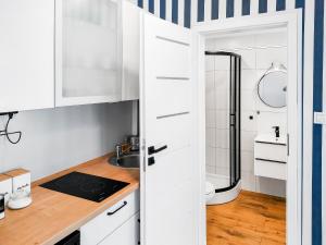 a small kitchen with white cabinets and a sink at Luna Port w Rowach in Rowy +18 photos