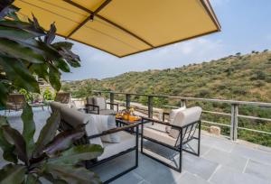 a patio with chairs and a table on a balcony at SaffronStays Moringa Valley - Oak Villa in Udaipur
