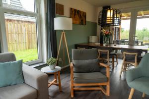 a living room with chairs and a dining room table at Waterdorp Burdaard in Burdaard