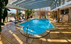 a swimming pool in a house with chairs around it at Studio 2 personnes avec Terrasse Literie-Serviettes-Ménage Fin de Séjour INCLUS in Bolquere Pyrenees 2000