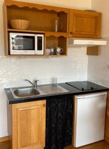 a kitchen with a sink and a microwave at Studio 2 personnes avec Terrasse Literie-Serviettes-Ménage Fin de Séjour INCLUS in Bolquere Pyrenees 2000