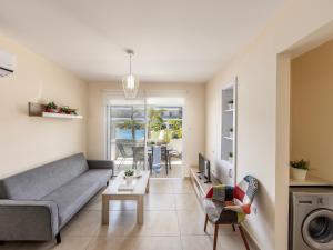 een woonkamer met een bank en een tafel bij Mythical Sands Resort in Protaras