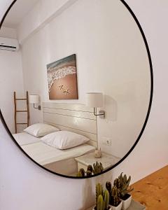 a mirror in a room with a bed and a table at Aegeo Inn in Antiparos