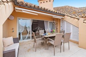 Un comedor con mesa y sillas en un patio. en Penthouse Paradise - Sotogrande, en Sotogrande
