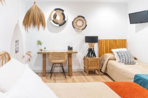 a living room with a bed and a desk with a chair at Hotel Las Américas in Málaga
