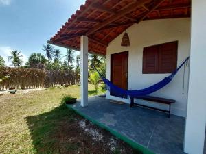 a porch of a house with a hammock on it at Casastral Atins in Barreirinhas