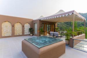 a house with a patio with a table and chairs at SaffronStays Moringa Valley - Oak Villa in Udaipur