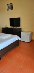 a bedroom with a bed and a flat screen tv at Vilele Brise de Mer in 2 Mai