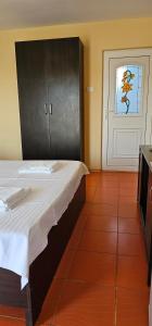 a bedroom with a bed and a door with a window at Vilele Brise de Mer in 2 Mai