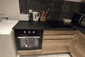 a kitchen with a black counter top with a stove at F2 en centre ville proche gare in Beauvais
