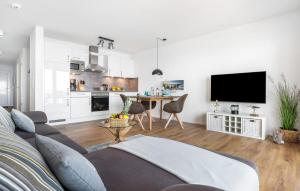 a white living room with a couch and a table at Strandläufer in Olpenitz