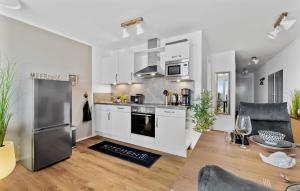 a kitchen with white cabinets and a stainless steel refrigerator at Hafendiamant in Olpenitz
