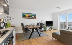 a kitchen and dining room with a table in a kitchen at Hafendiamant in Olpenitz