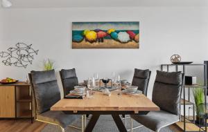 a dining room table with chairs and a painting of birds at Hafendiamant in Olpenitz +18 photos