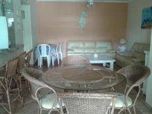 ein Wohnzimmer mit Tisch und Stühlen und einer Couch in der Unterkunft Apartamento na Praia Grande em Ubatuba in Ubatuba