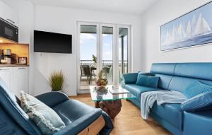 a living room with two blue couches and a table at Ms Admiral in Olpenitz