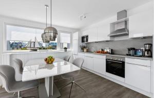 een witte keuken met een witte tafel en stoelen bij Beluga in Olpenitz +21 foto's