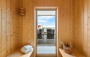 Una habitación con paredes de madera y una puerta de cristal con patio. en Awesome Home In Olpenitz With Sauna, en Olpenitz
