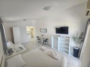 a white living room with a couch and a tv at Guest house Silvija - sea view in Primošten