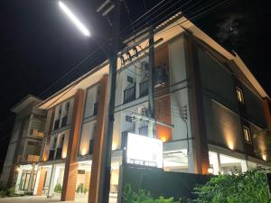 a building with a sign in front of it at night at อยู่สบายเพลส in Chonnabot