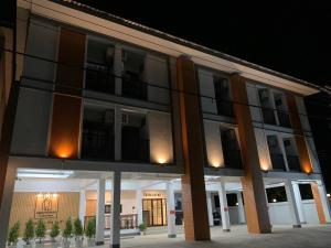 a large building with a lit up facade at night at อยู่สบายเพลส in Chonnabot