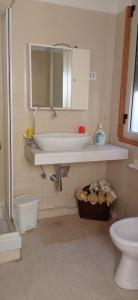 a bathroom with a sink and a toilet and a mirror at Relax sul mare di Sicilia in Gela +11 photos
