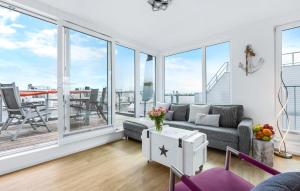 a living room with a couch and large windows at Ankerplatz19B in Olpenitz