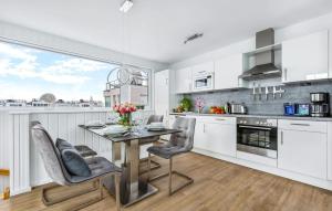 a kitchen with white cabinets and a table and chairs at Ankerplatz19B in Olpenitz