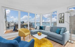 een woonkamer met een bank en stoelen en een groot raam bij Stockholm in Olpenitz