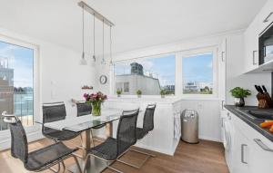 een witte keuken met een eettafel en stoelen bij Stockholm in Olpenitz