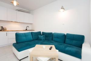 Apartament Morski في شتوتوفو: غرفة معيشة مع أريكة زرقاء وطاولة