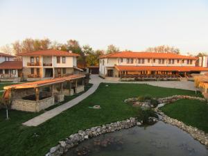 a resort with a pond and a bridge and buildings at Stara Pliska Complex in Pliska