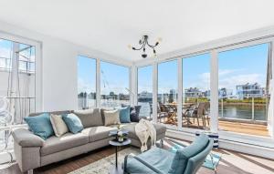 Una sala de estar con un sofá y grandes ventanales. en La Marina, en Olpenitz