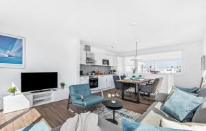 Una sala de estar blanca con un sofá y una mesa. en La Marina, en Olpenitz