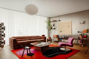 a living room with a brown couch and a red rug at Edgar Suites Marais - Temple in Paris
