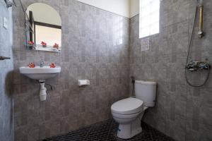 een badkamer met toilet en wastafel bij Kubu Lestari Homestay in Sanur