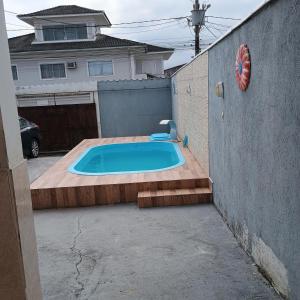 a small swimming pool in a yard next to a house at Linda casa com piscina in Saquarema