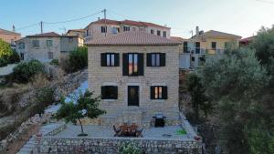 a small brick house with a table in front of it at Chrysavgi Stone House in Meganisi