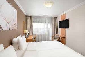 מיטה או מיטות בחדר ב-Danubius Hotel Arena +31 תמונות